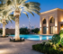 Dubai villa landscape lighting with black palm tree ring lights featuring adjustable LED spotlights, pathway illumination, Arabic architecture facade lighting, pool area with tropical garden demonstrating professional UAE outdoor lighting design